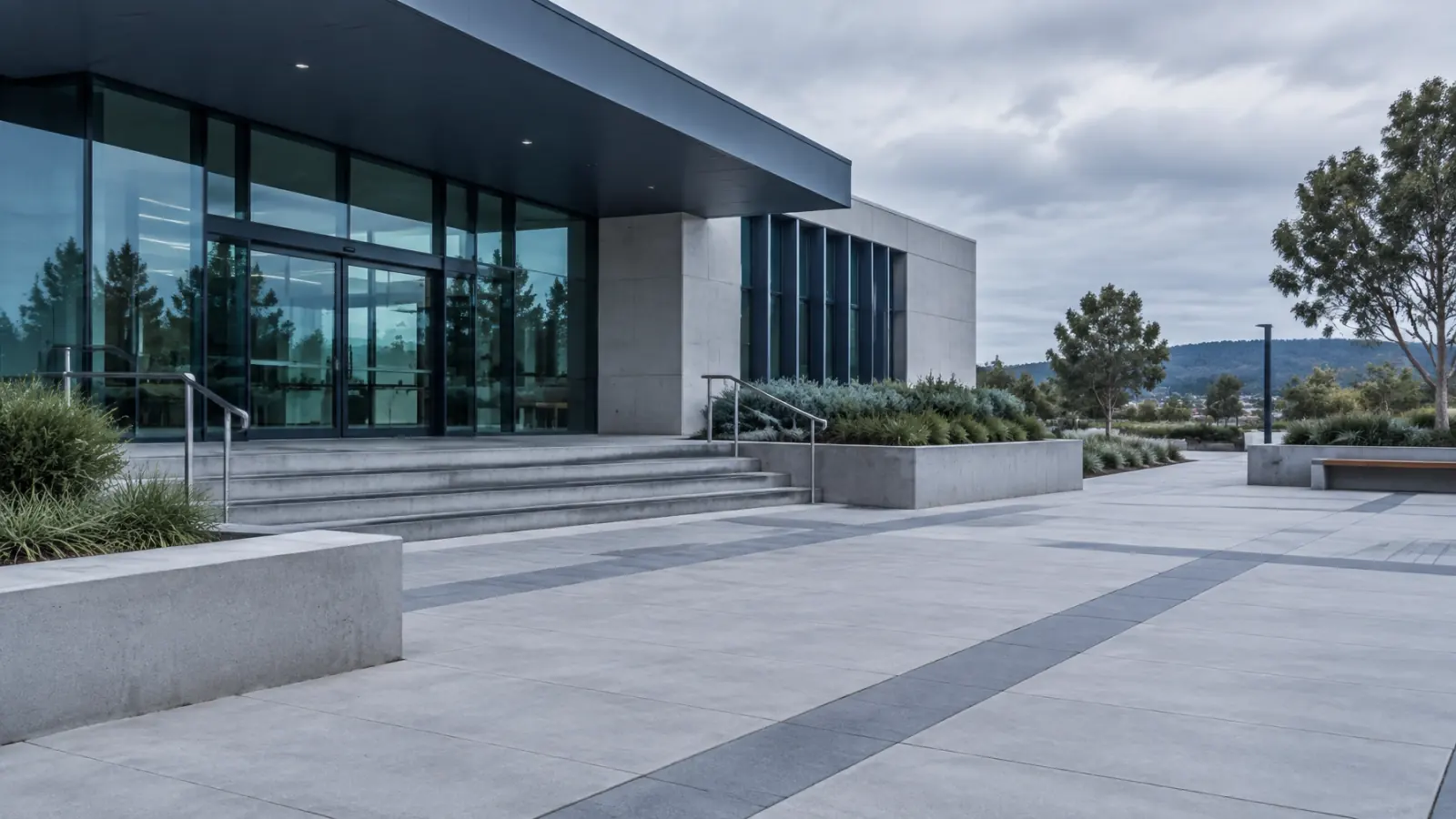 A modern regional civic building with glass, concrete, and open pavement